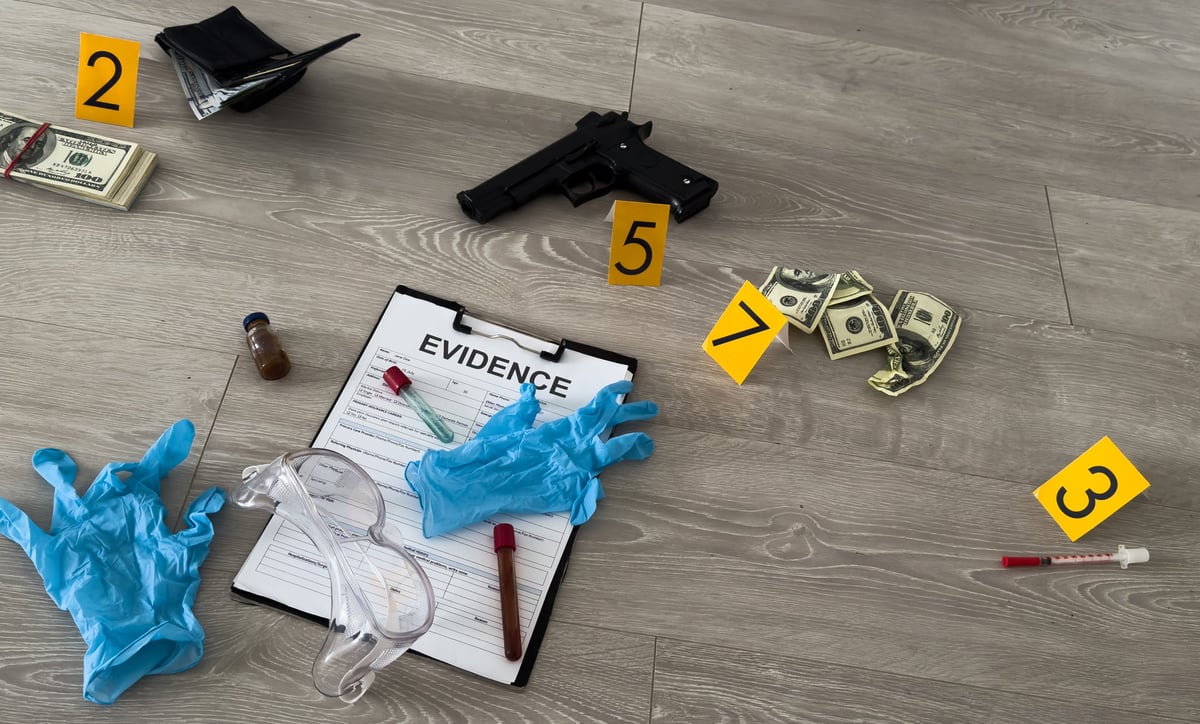 Crime scene, physical evidence. Gun handcuffs, money, dollar on a dark background. High quality photo